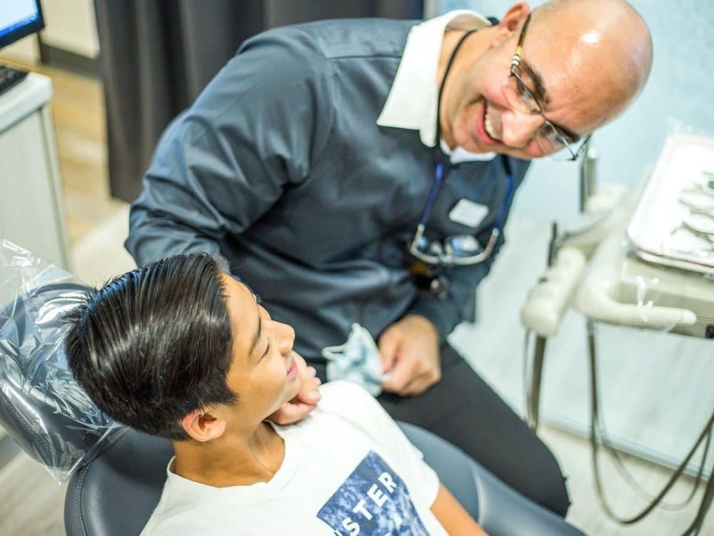 Dr. Garate reassuring a young patient in the treatment chair