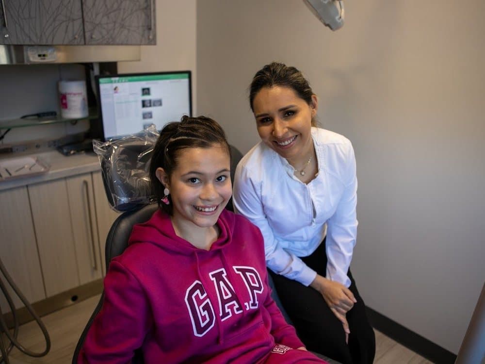 A young patient and Dr. Falcon reviewing digital X-rays together at Perfect Smiles California